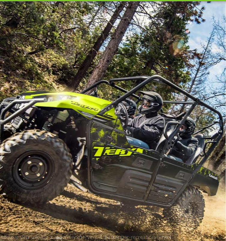 Two people in a yellow and black UTV driving through a forest.